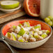 A Carlisle Fireball melamine cereal bowl filled with cereal and fruit.