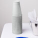 A white table set with white and blue plastic cups.