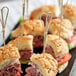 A tray of sandwiches with Tablecraft bamboo heart picks in them.