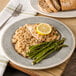 A Carlisle Grove melamine plate with rice, asparagus, and chicken with a lemon slice on top.