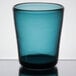 A teal Carlisle plastic double rocks glass on a table.