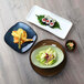 A rectangular TuxTrendz Artisan Agave china tray with sushi and salad on a wood table.