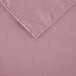 A pink rectangular polyester cloth table cover with a folded edge.