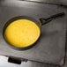 A Prince Castle non-stick egg ring with yellow liquid in it.