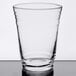 An Arcoroc clear glass on a table with a white background.