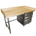 An Advance Tabco wooden work table with a stainless steel base and metal drawers.