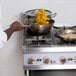 A man cooking food on a Cooking Performance Group gas range.