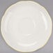 A CAC ivory saucer with a scalloped edge and yellow trim.