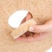 A hand holding a 3M Natural Blend tan heavy duty burnishing floor pad.