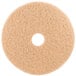 A white circular 3M tan burnishing floor pad with a hole in the middle.