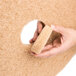 A hand holding a piece of sandpaper.