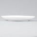 An Arcoroc white porcelain B&B plate with a small rim.