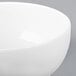 A close-up of a white Arcoroc Candour coupe bowl with a white rim.