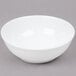 An Arc Cardinal white porcelain bowl with a white rim on a gray surface.