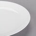 An Arcoroc white porcelain salad plate with a white rim.