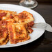 A white oval porcelain platter with a plate of ravioli and a fork.