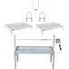 A metal table and shelves with a Party Que Charcoal Rotisserie Grill and parts.