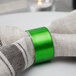 A green Tabletop Classics by Walco Forest Green napkin ring on a fabric surface.