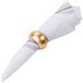 An American Atelier gold acrylic napkin ring on a white napkin.