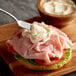 A sandwich with ham and cheese and AAK Select Recipe mayonnaise on a cutting board.