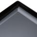 A close-up of a black WNA Comet rectangular tray.