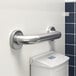 A white metal wall-mounted Lavex restroom grab bar.