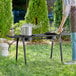 A person using a Backyard Pro double burner outdoor patio stove to cook outside.