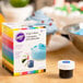 A box of Wilton gel food coloring bottles with white caps.