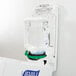 A Purell hand sanitizer dispenser on a wall.