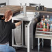 A woman opening a Beverage-Air stainless steel dual zone kegerator.