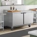 A stainless steel two-door worktop freezer on wheels, designed for commercial kitchen use.