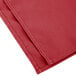 A folded red Intedge cloth napkin.