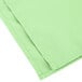 A folded seafoam green cloth napkin.