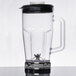 A clear Waring blender jar with a black lid.
