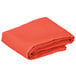 A folded orange cloth table cover on a white background.