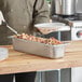 A Vollrath stainless steel hotel pan with food in it.