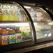 A Vollrath countertop display case with drinks and beverages inside, including a close-up of a bottle with a yellow label.