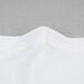 A close up of a white spandex table cover with a folded edge.