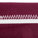 A burgundy spandex table cover with a white zipper.