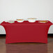 A crimson Snap Drape spandex table cover on a table with food.