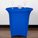 A blue Snap Drape spandex table cover on a round table with two wine glasses on it.