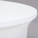 A white Snap Drape spandex table cover on a round table.