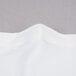 A close-up of a white fabric with a folded edge.