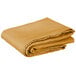 A folded gold square table cover on a white background.