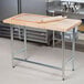 A rolling pin on an Advance Tabco wood top work table.