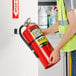 A man in a safety vest holding a Badger Advantage fire extinguisher.