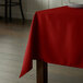 A red Intedge square tablecloth on a table.