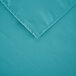 A teal rectangular cloth table cover with a folded edge.