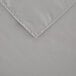 A close up of a gray rectangular cloth with a folded edge.
