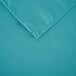 A teal rectangular cloth table cover with a folded edge.